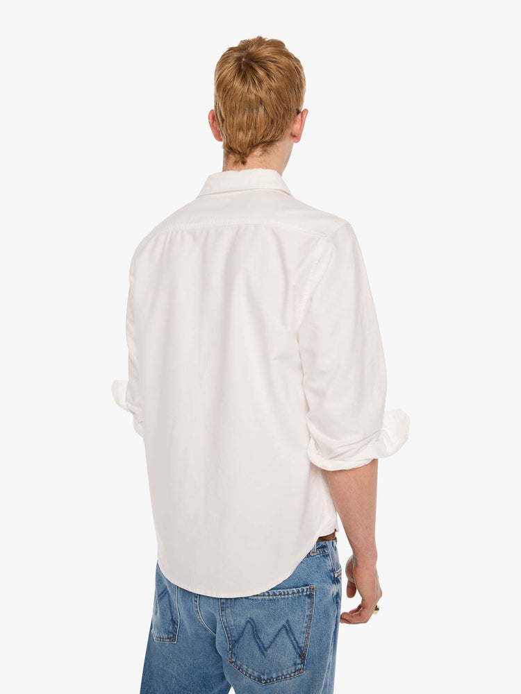 Back view of  man in the top is designed in white with a navy M embroidered on the chest.