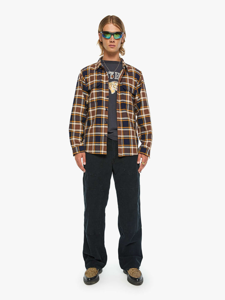 Full body view of a man in black, brown, yellow collared button-up with patch pockets, long sleeves and a classic fit.