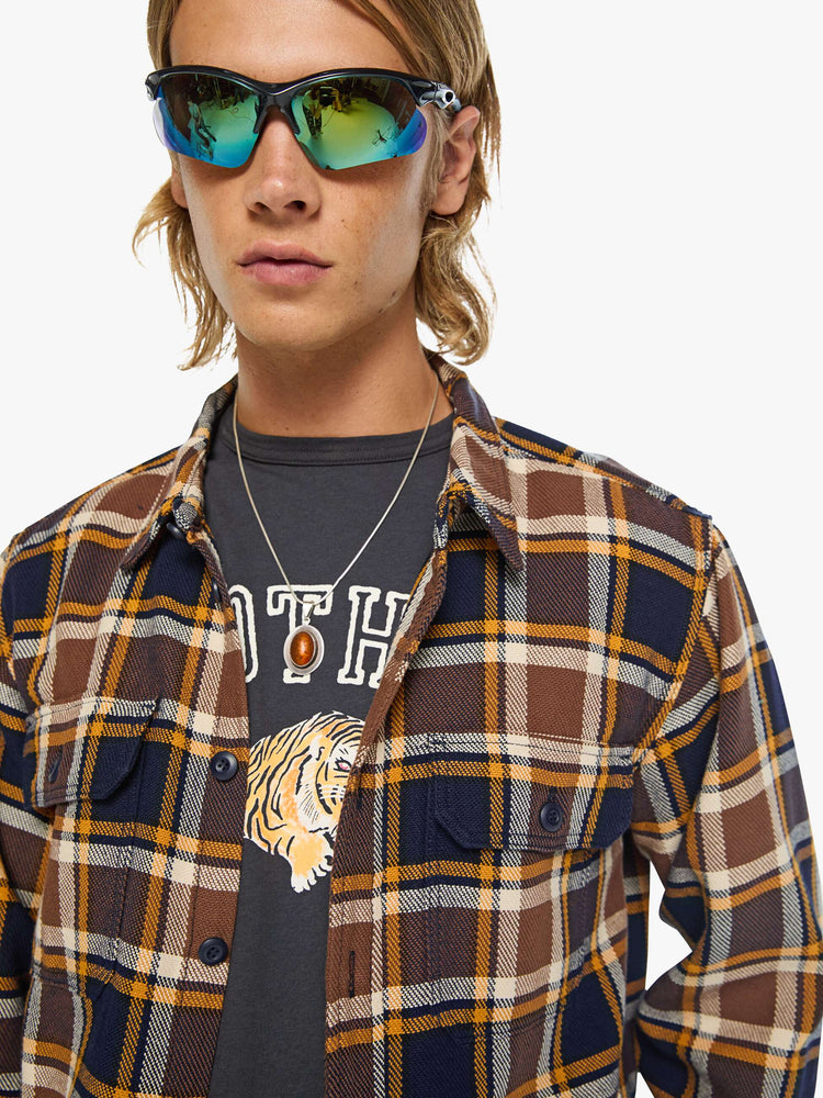 Close up view of a man in black, brown, yellow collared button-up with patch pockets, long sleeves and a classic fit.