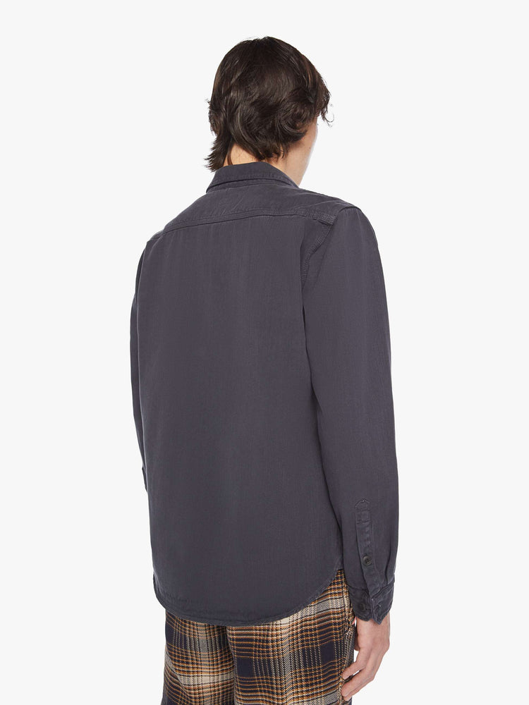 Back view of a mens classic button-up shirt with double patch pockets, long sleeves and a curved hem in a faded black hue.