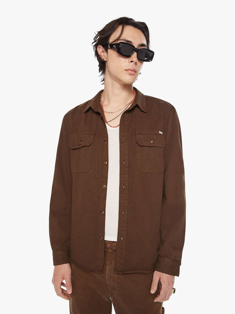 Front view of a men's classic button-up shirt with double patch pockets, long sleeves and a curved hem in a dark brown hue.