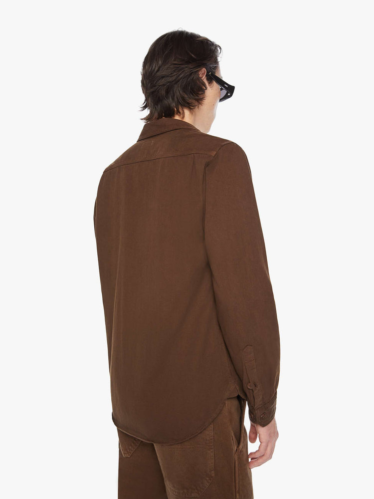 Back view of a men's classic button-up shirt with double patch pockets, long sleeves and a curved hem in a dark brown hue.