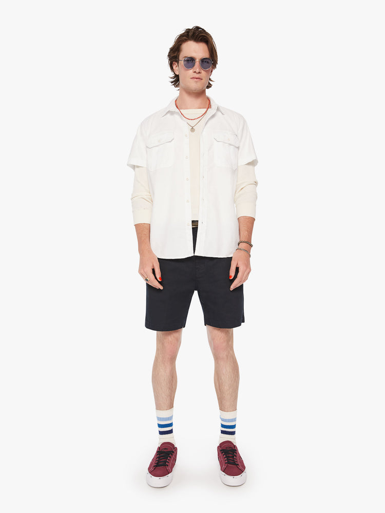 Full body view of men short sleeve button-up with patch pockets at the chest and a curved hem in a bright white hue.