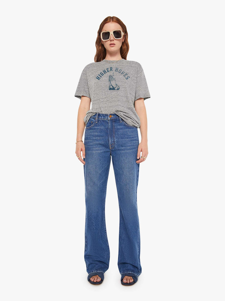 WOMEN front full body view of a woman in a heather grey unisex crew neck tee featuring a faded blue graphic of hands of the words "HIGHER HOPES".