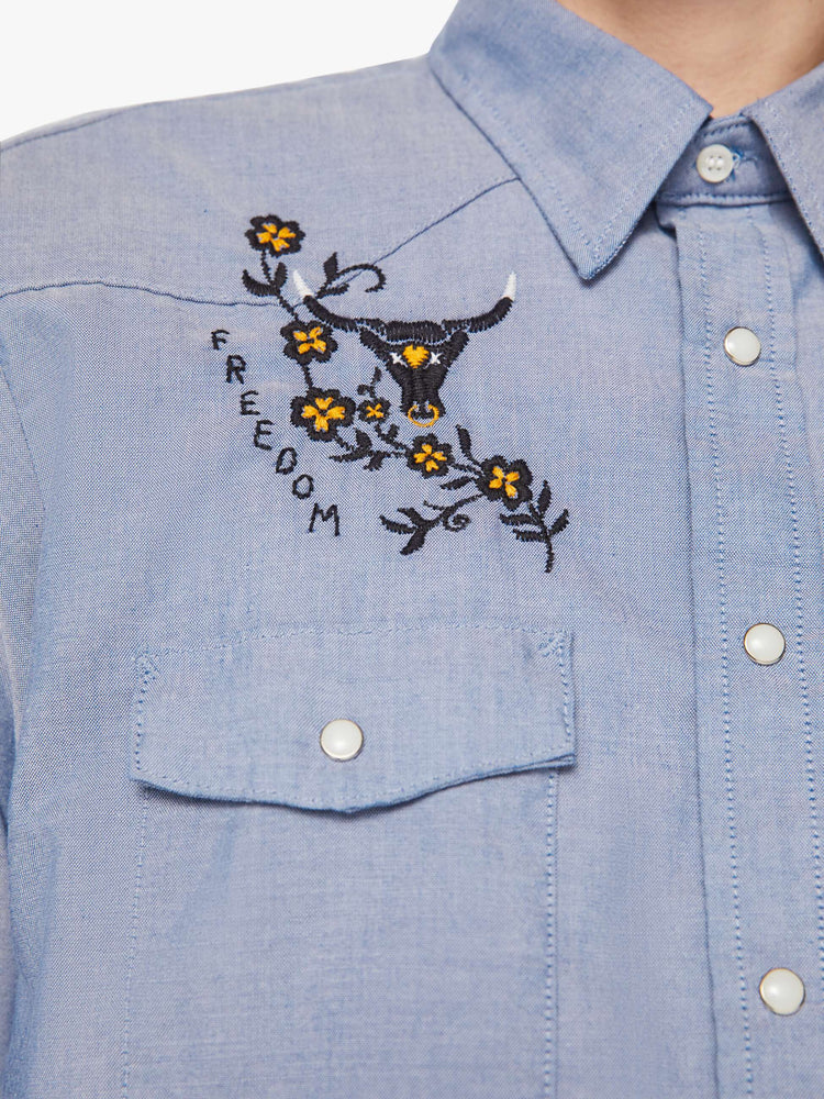Swatch view of a men classic long sleeve button-up with Western-inspired patch pockets in a light blue hue with embroidered bulls, flowers and text on the chest.