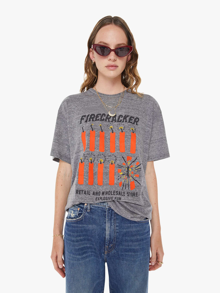 WOMAN front view in an oversized tee in heathered grey, the tee features a firecracker graphic in red and black on the front.