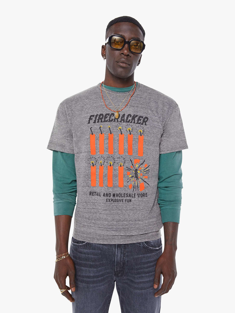 MEN front view in an oversized tee in heathered grey, the tee features a firecracker graphic in red and black on the front.