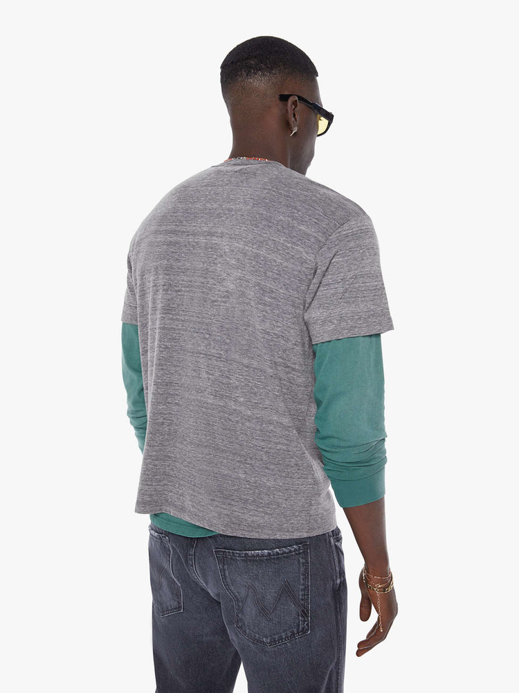 MEN back view in an oversized tee in heathered grey, the tee features a firecracker graphic in red and black on the front.
