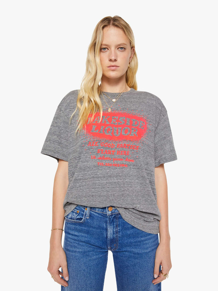 WOMAN front view in a heathered grey tee with a neon orange liquor store graphic on the front.