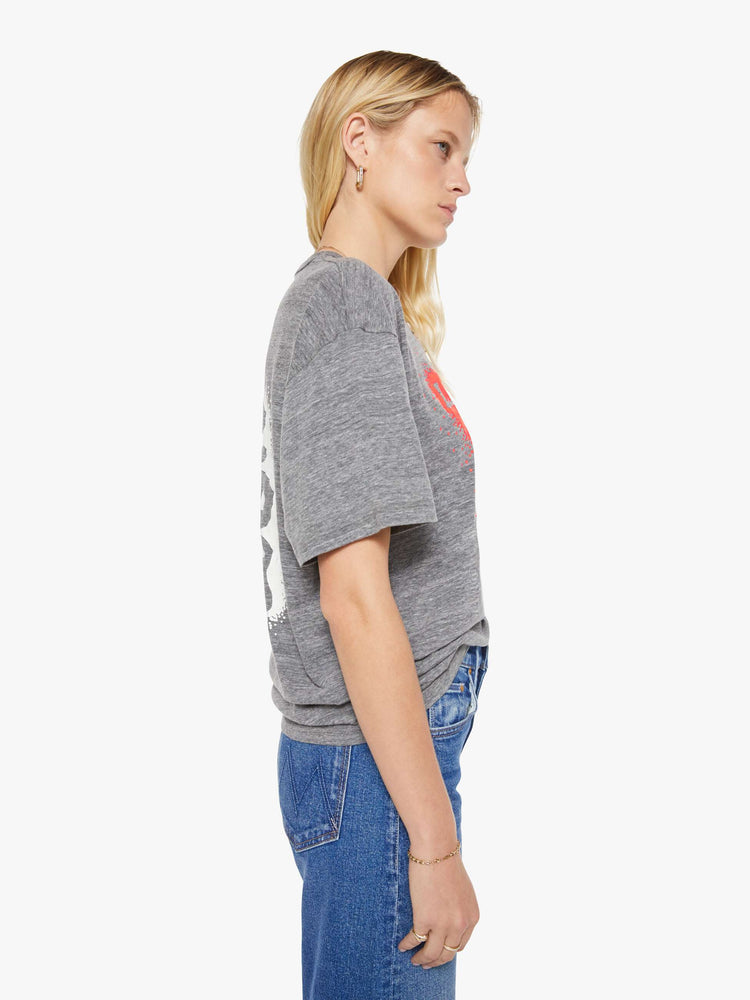 WOMAN side view in a heathered grey tee with a neon orange liquor store graphic on the front.