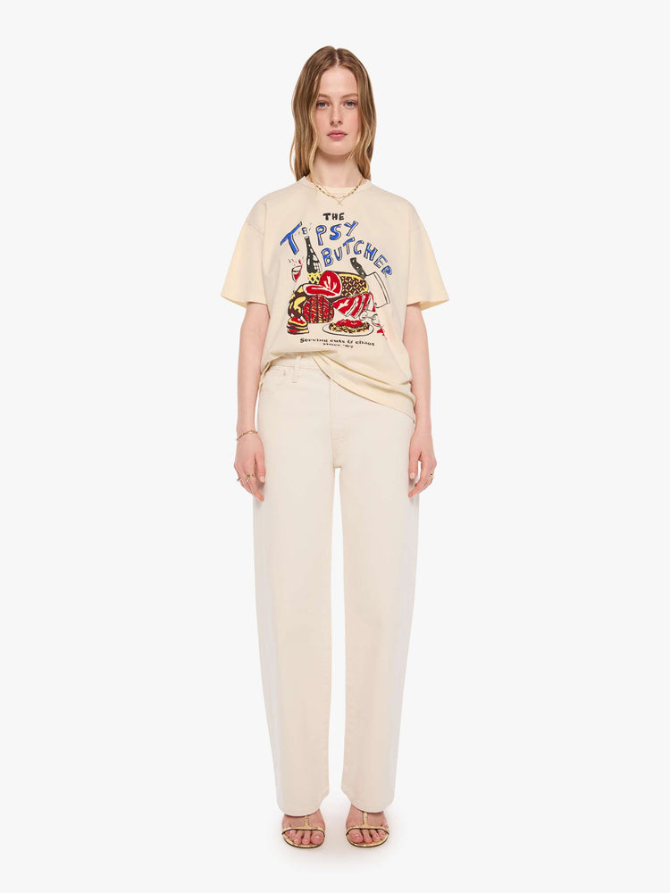 WOMAN front full body view in a cream tee features a vintage-inspired butcher-shop graphic on the front.
