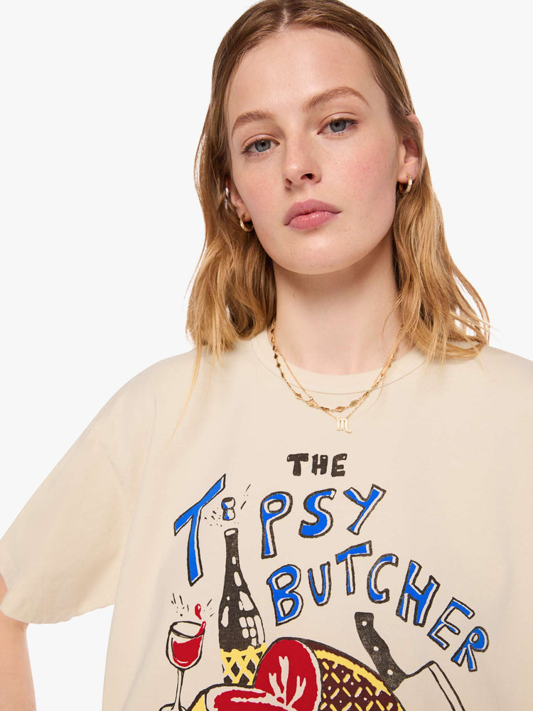 WOMAN close up view in a cream tee features a vintage-inspired butcher-shop graphic on the front.