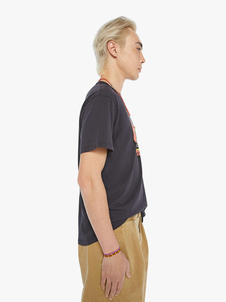 MEN side view in a faded black oversized tee with a faded graphic inspired by vintage camp store merch.