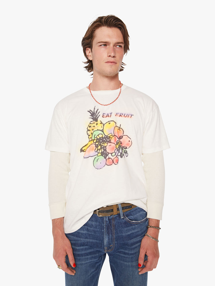 Side view of a men oversized tee with drop shoulders in white and the tee features a colorful fruit graphic and text on the front.