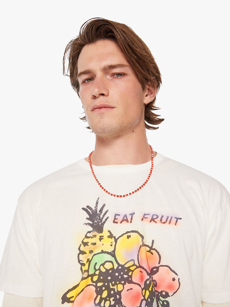 Close up view of a men oversized tee with drop shoulders in white and the tee features a colorful fruit graphic and text on the front.