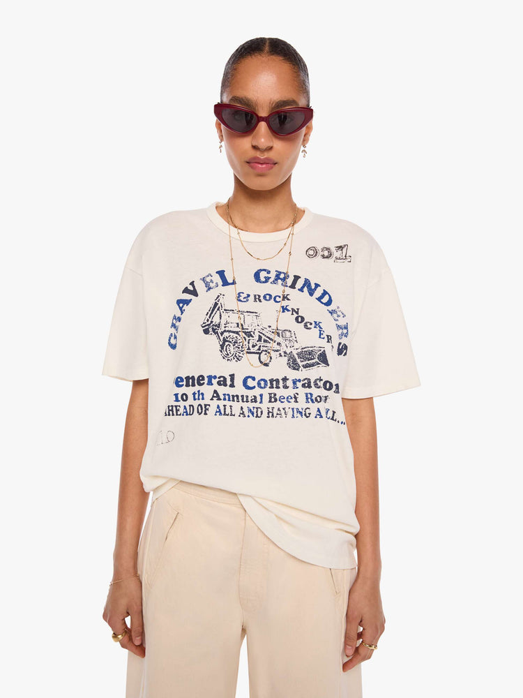 WOMAN front view in a off-white tee with a faded graphic on the front inspired by a vintage contractor's event tee.