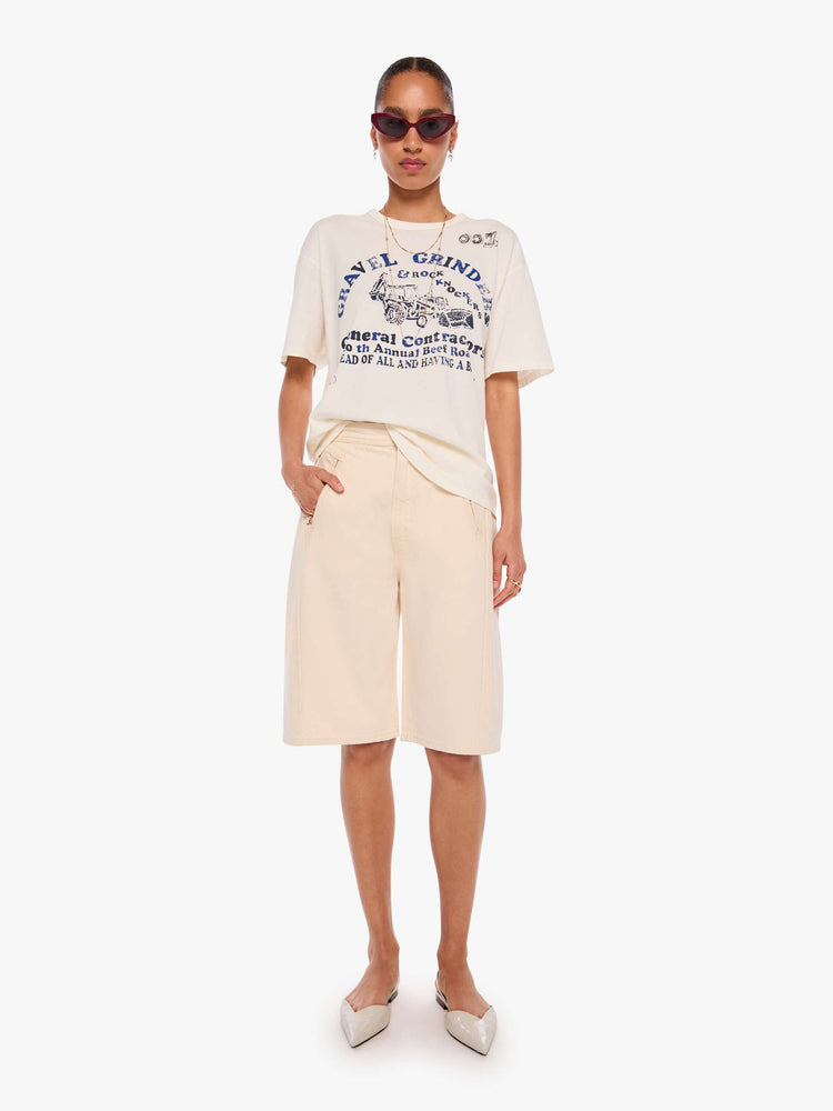 WOMAN full body view in a off-white tee with a faded graphic on the front inspired by a vintage contractor's event tee.