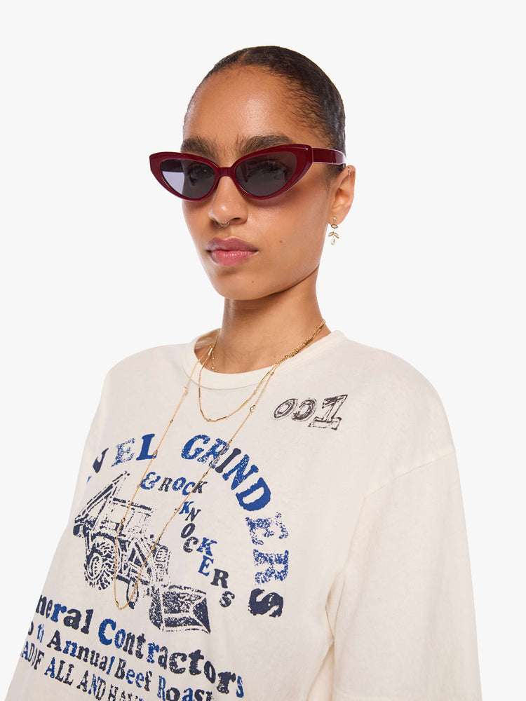 WOMAN close up view in a off-white tee with a faded graphic on the front inspired by a vintage contractor's event tee.