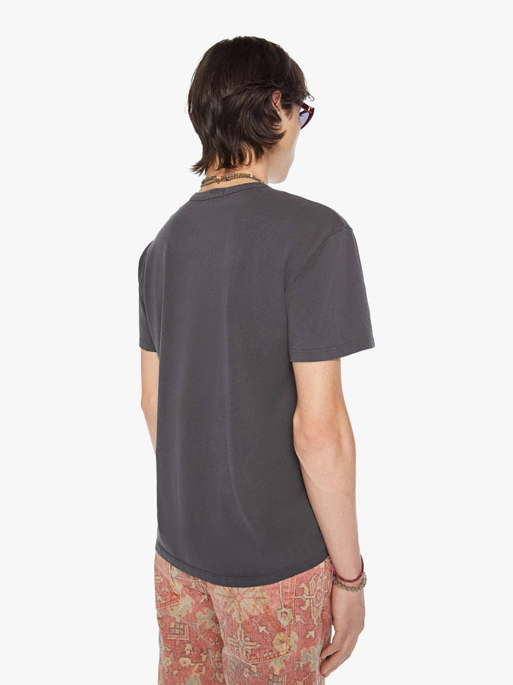 Back view of a men oversized tee with drop shoulders and a loose fit in a faded black tee with a faded sun hat graphic and text.