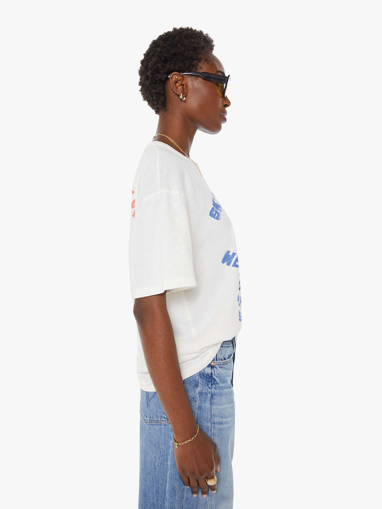 WOMAN side view in a white tee features a faded graphic inspired by a retro ski school on the front.