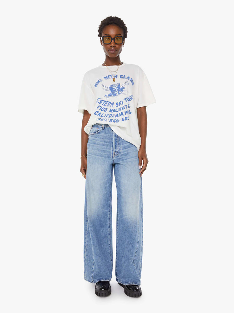 WOMAN full body view in a white tee features a faded graphic inspired by a retro ski school on the front.