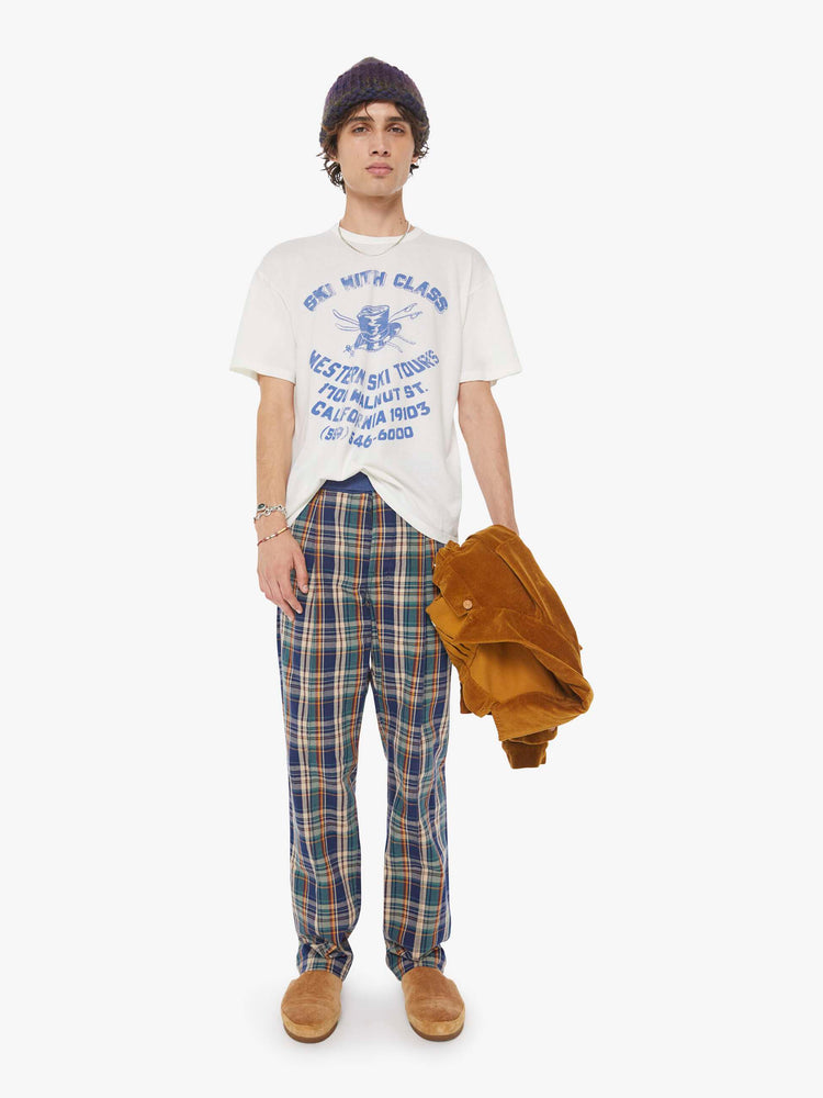 MEN full body view in a white tee features a faded graphic inspired by a retro ski school on the front.