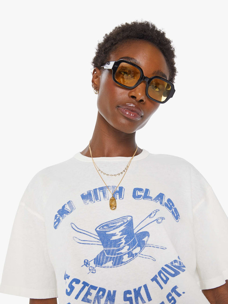 Close up view in a white tee features a faded graphic inspired by a retro ski school on the front.