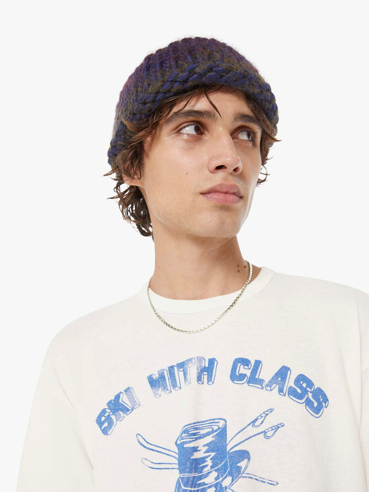 MEN close up view in a white tee features a faded graphic inspired by a retro ski school on the front.
