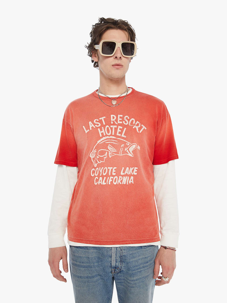 MEN front view in an oversized tee in a red wash with an off-white graphic inspired by an old-school hotel logo.