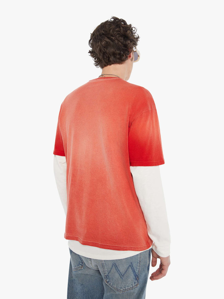MEN back view in an oversized tee in a red wash with an off-white graphic inspired by an old-school hotel logo.