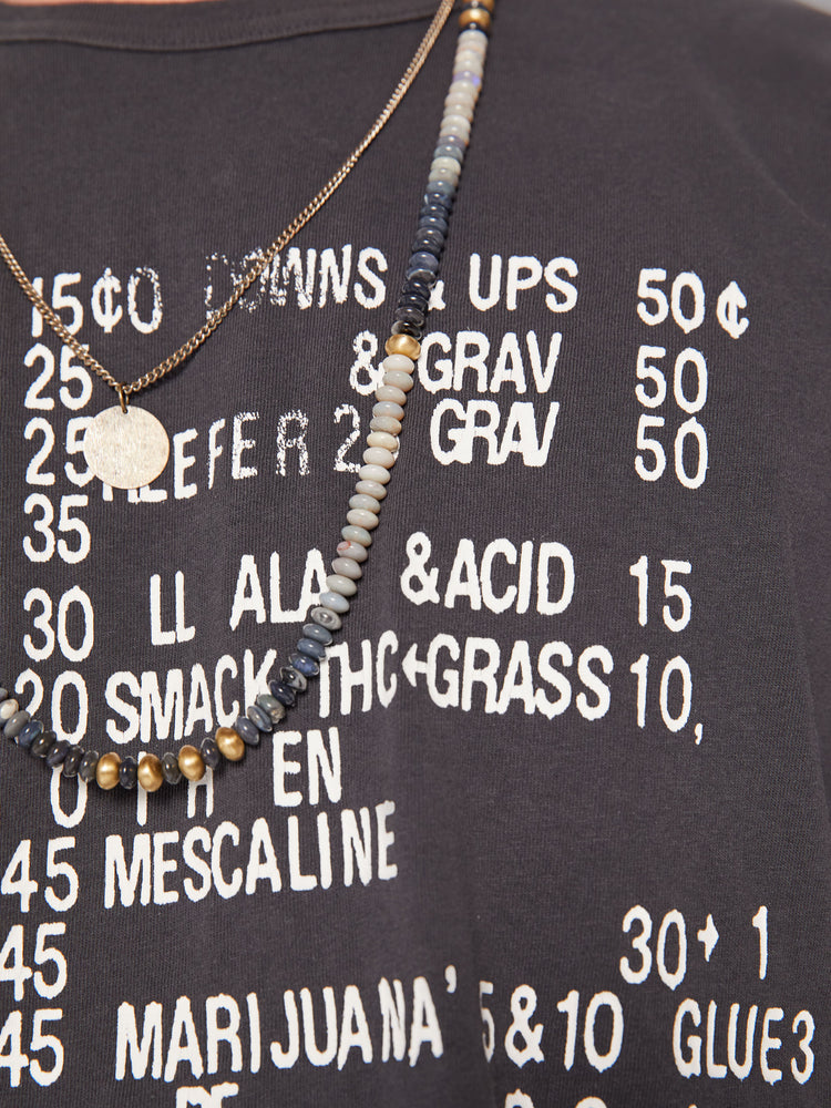 Swatch view of a men oversized tee with drop shoulders and a loose fit in a dark grey hue with a menu of illicit substances on the front.