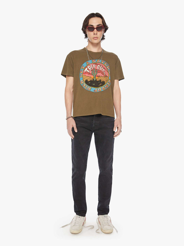 Full body view of a men olive-brown hue oversized tee with drop shoulders and a loose fit with a desert themed graphic.