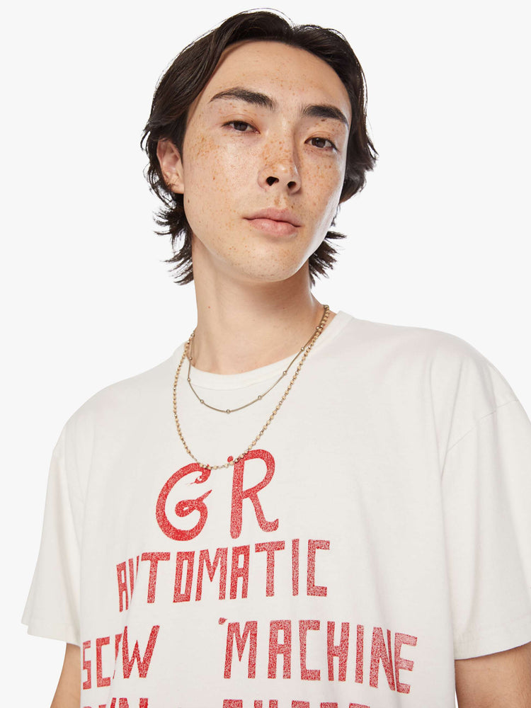 Close up  view of a men white with faded red text oversized tee with drop shoulders and a loose fit.