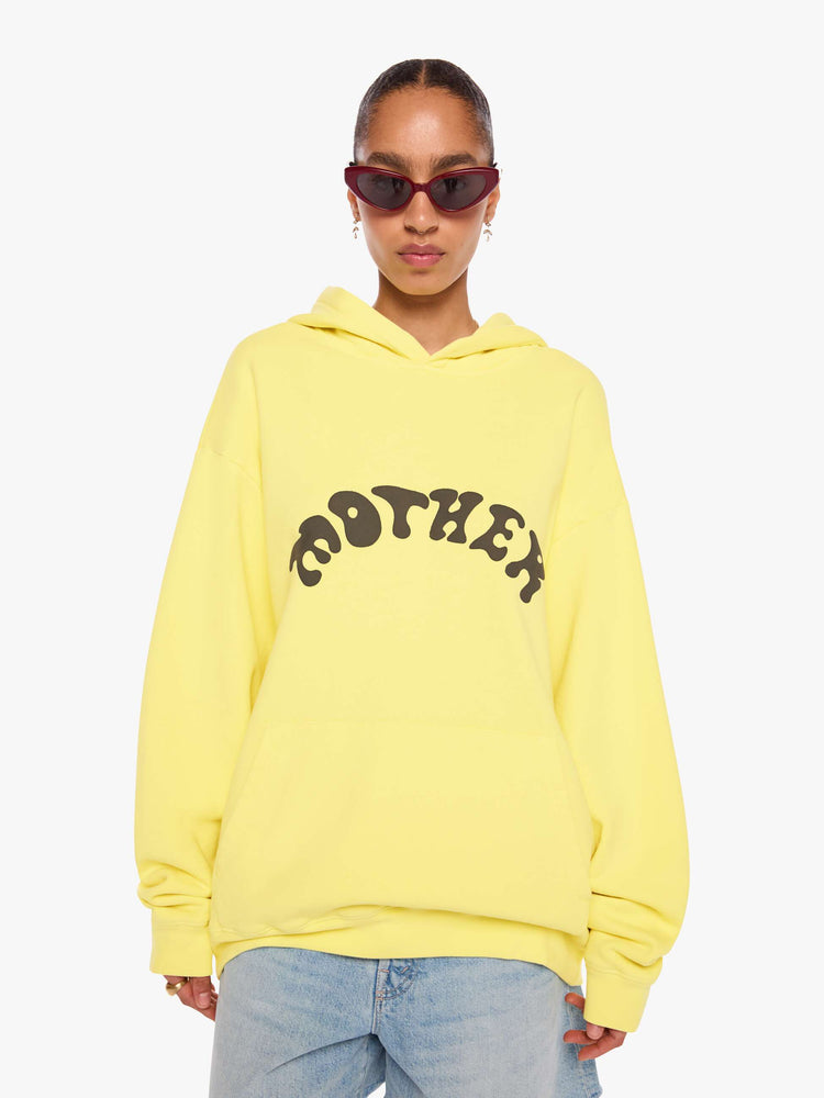 WOMAN front view of a yellow hoodie features MOTHER's name in dark grey across the front.