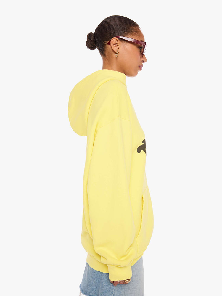 WOMAN side view of a yellow hoodie features MOTHER's name in dark grey across the front.