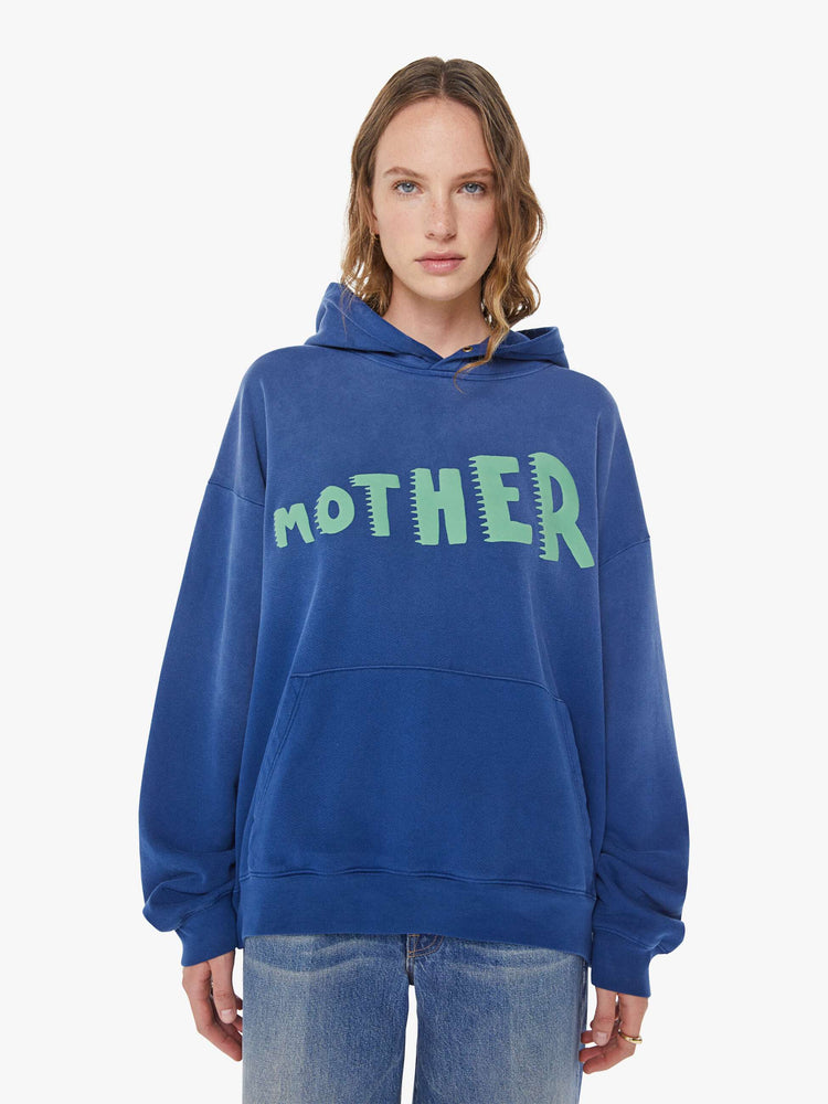 WOMAN front view of a blue  oversized hoodie with drop shoulders, ribbed hems and a front patch pocket. 
