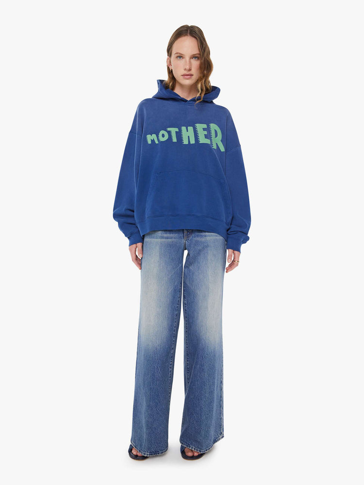 WOMAN front full body view of a blue  oversized hoodie with drop shoulders, ribbed hems and a front patch pocket.