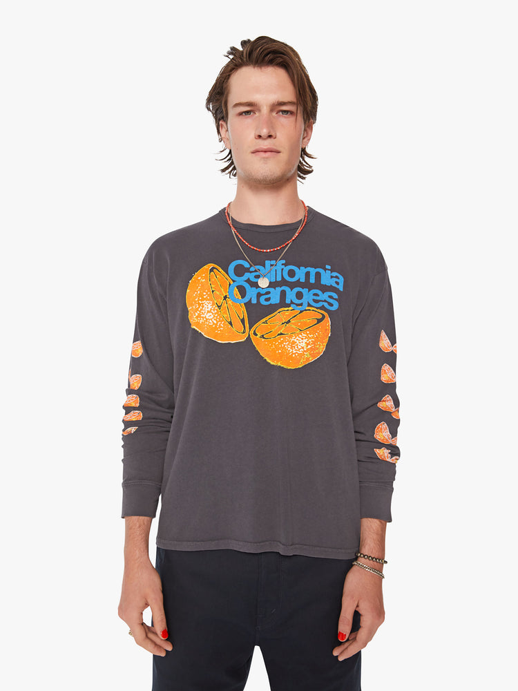 Front view of men oversized long sleeve tee with drop shoulders in a dark grey hue with orange slices down the arm. 