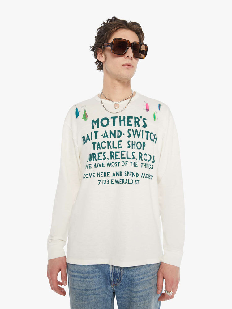 MEN front view of rugby style tee in off white with a green text graphic on the front and colorful lures across the shoulders.