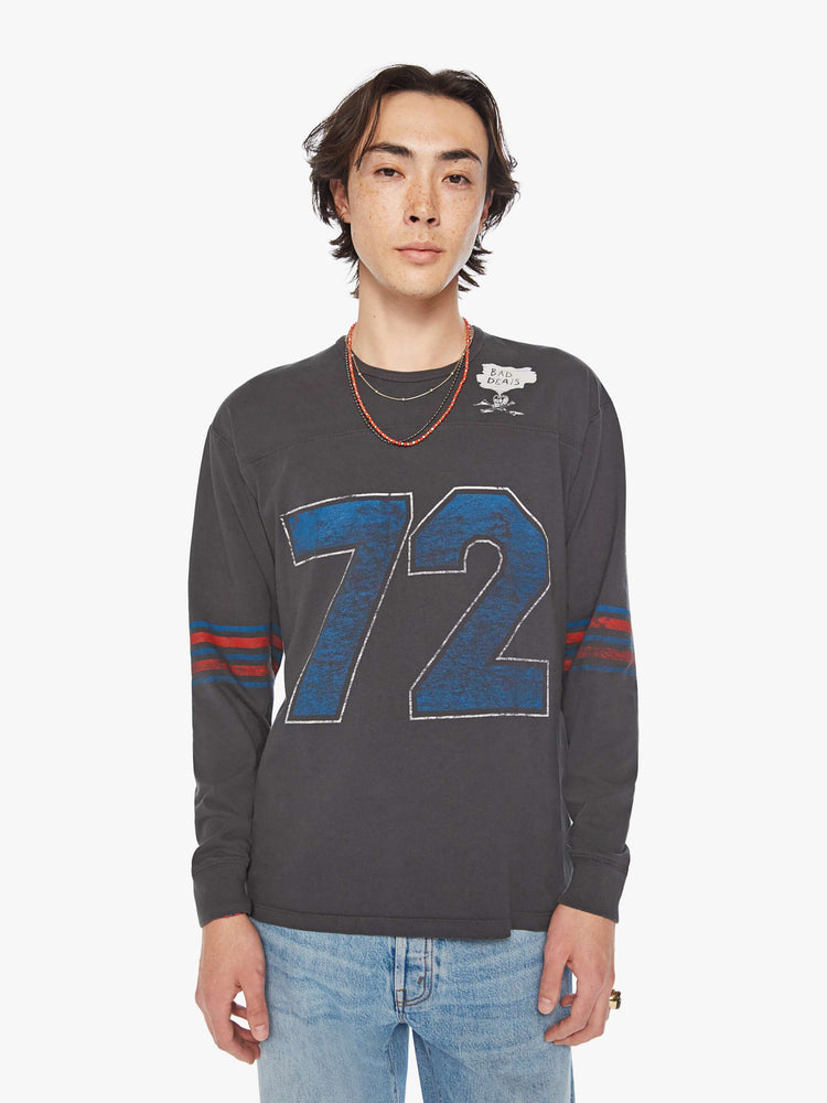 Front view of a men football tee with a crew neck, long sleeves, drop shoulders and a boxy fit with hand-drawn skeleton doodles, a number on the front and horizontal stripes on the sleeves in a faded grey hue.