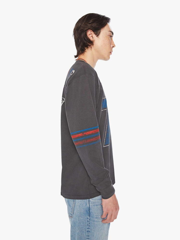 Side view of a men football tee with a crew neck, long sleeves, drop shoulders and a boxy fit with hand-drawn skeleton doodles, a number on the front and horizontal stripes on the sleeves in a faded grey hue.
