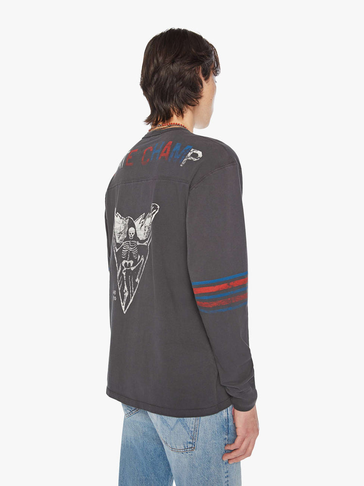 Back view of a men football tee with a crew neck, long sleeves, drop shoulders and a boxy fit with hand-drawn skeleton doodles, a number on the front and horizontal stripes on the sleeves in a faded grey hue.