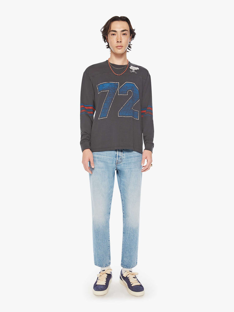 Full body view of a men football tee with a crew neck, long sleeves, drop shoulders and a boxy fit with hand-drawn skeleton doodles, a number on the front and horizontal stripes on the sleeves in a faded grey hue.