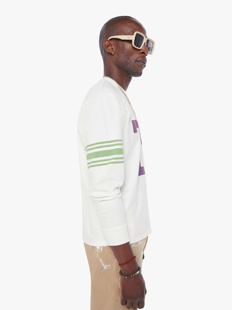 MEN side view in a white rugby-style tee with a crew neck, long sleeves with a checkered "75" graphic on the front, mint-green stripes on the sleeves and a tiger near the neck.