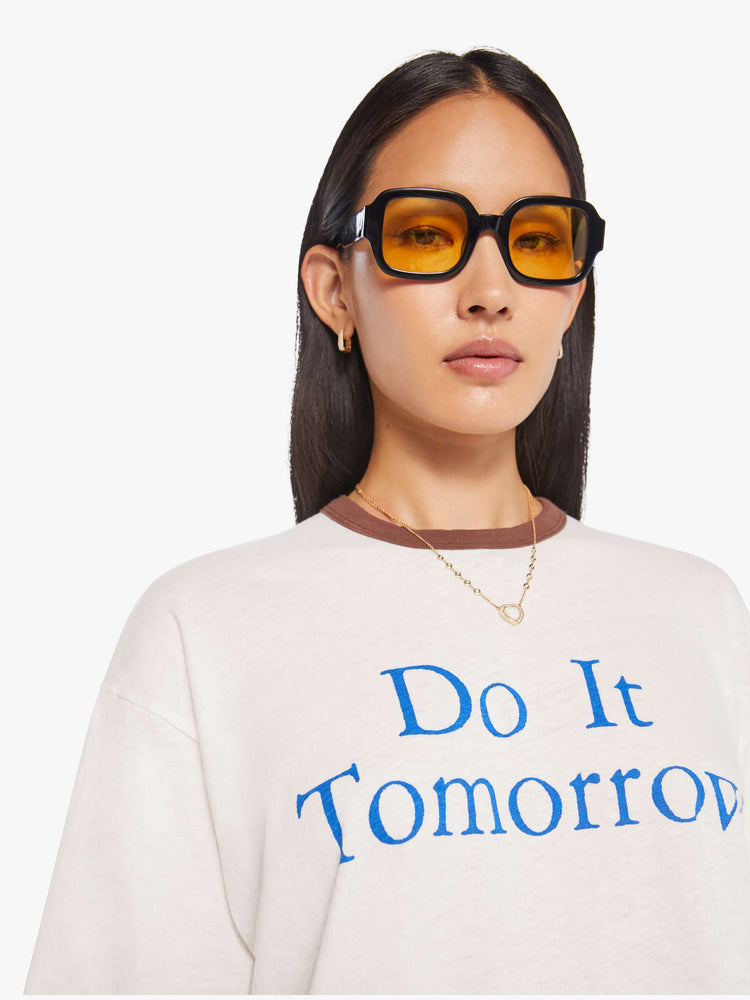 WOMEN close up view of an oversized tee with drop shoulders and a loose fit in white with brown trim.