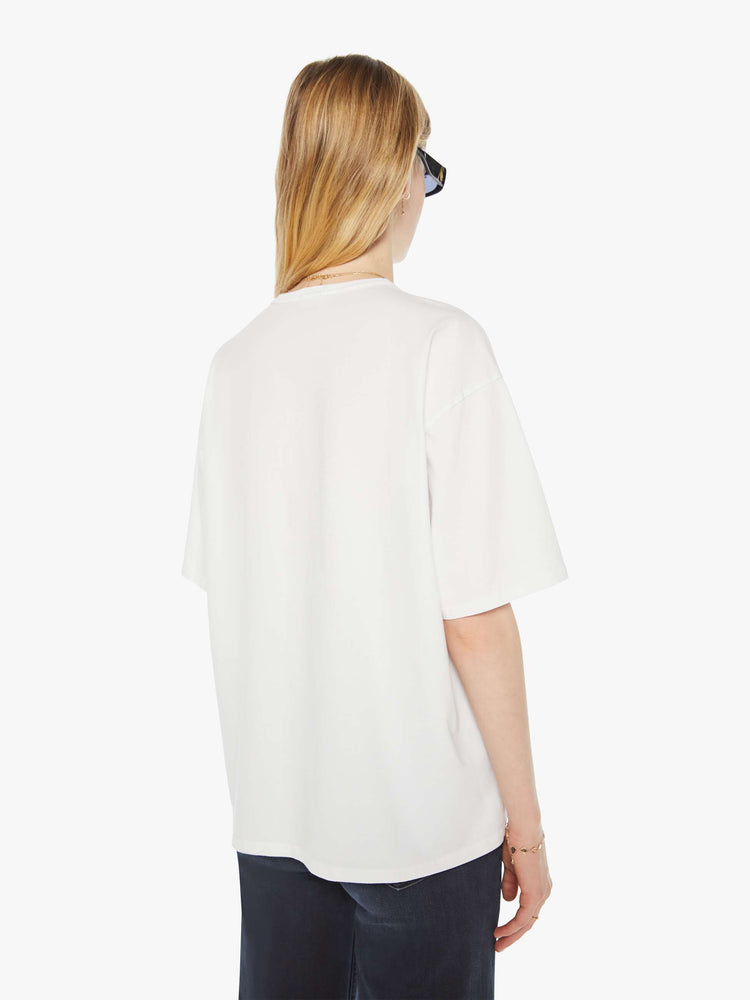 WOMAN back view in an oversized tee in white with hand-drawn graphic in blue and pink on the front inspired by a camp counselor tee.