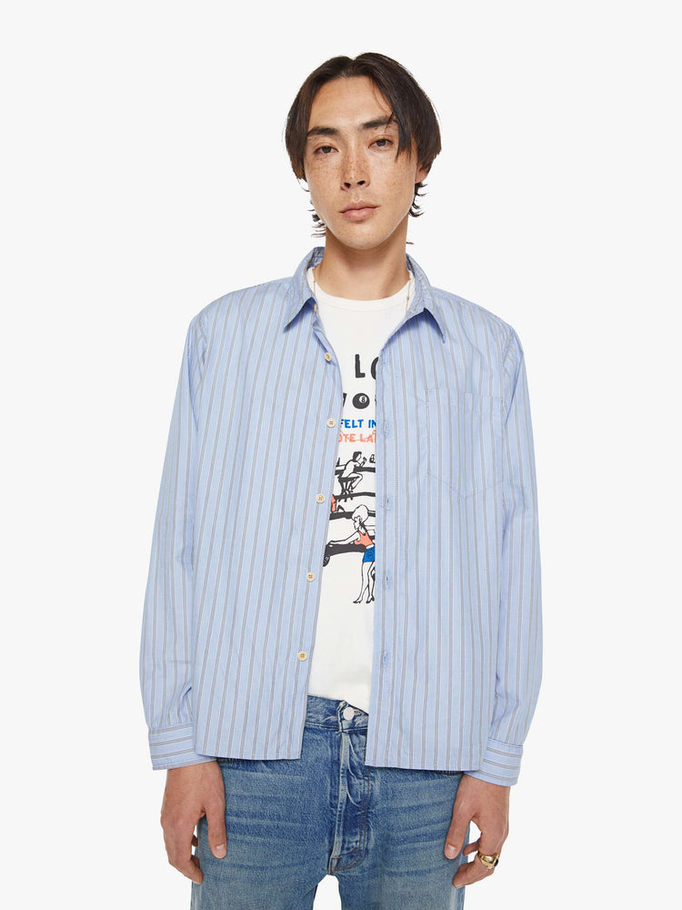 Front view of a man in a light blue, black and white stripe classic button-up with a loose fit and slightly cropped hem.