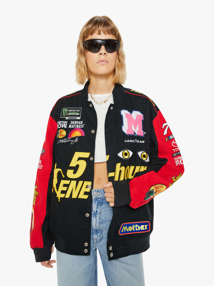 Front image of a woman wearing a racer jacket in black and red featuring various patches.