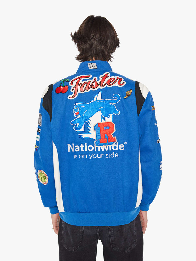 Back image of a mens blue racer jacket featuring assorted patches.