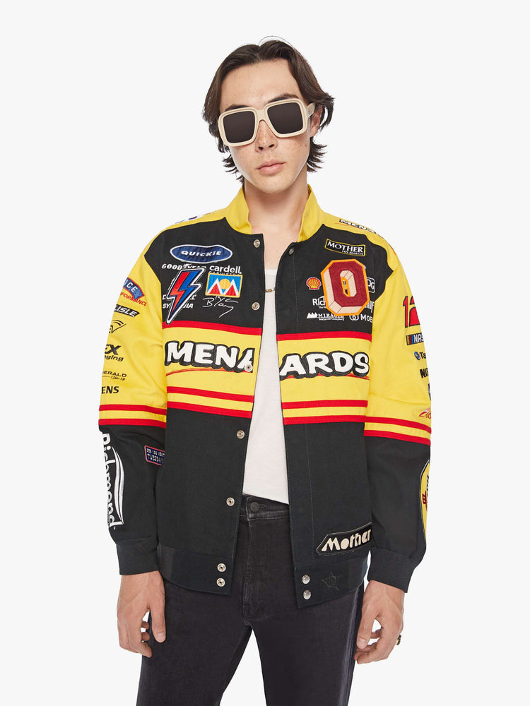 Front view of a men's racing jacket with drop shoulders, ribbed hems, snaps down the front and an oversized fit one of one combination of colors and patches inspired raceway logos.